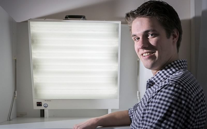 Stefan Knapen zit voor een daglichtlamp