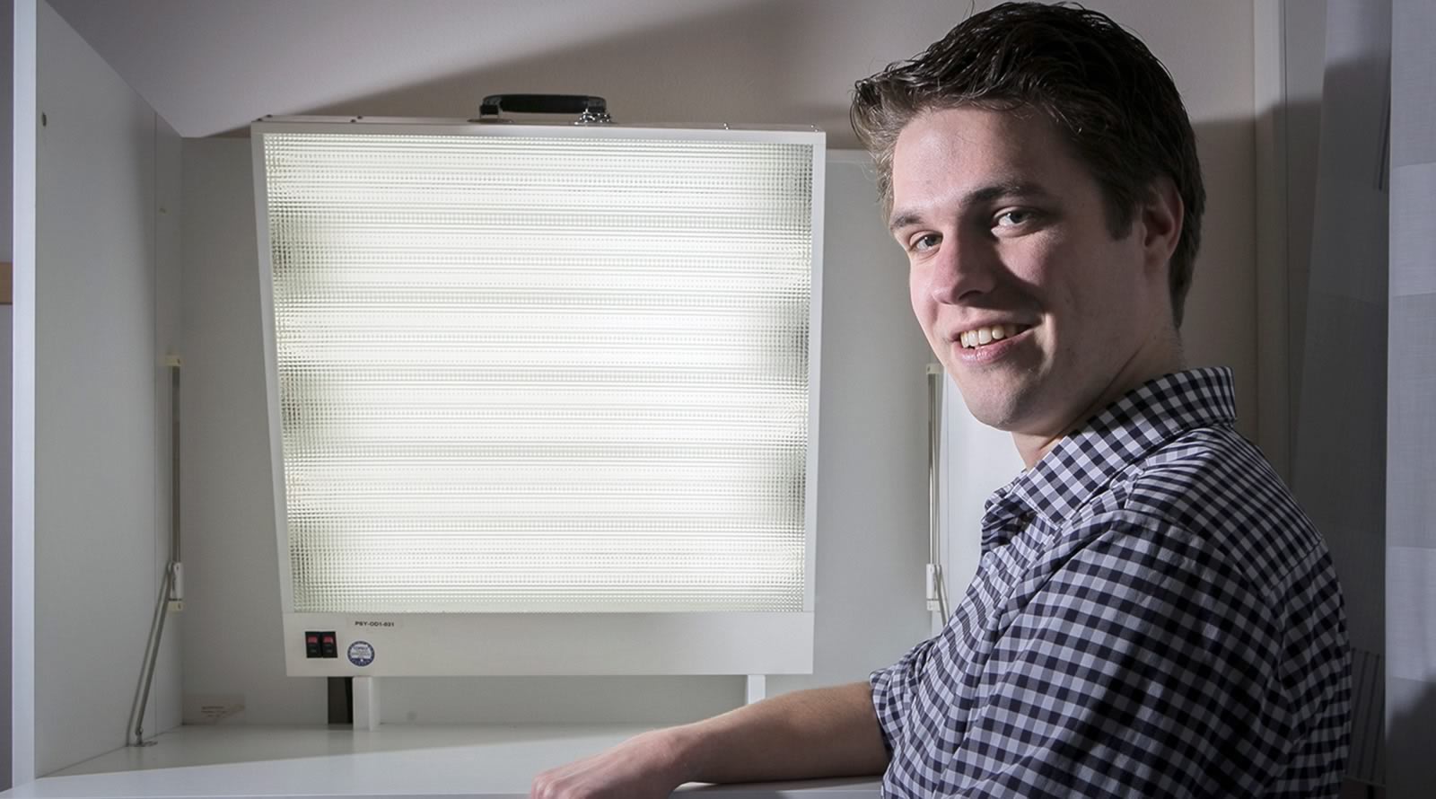 Stefan Knapen zit voor een daglichtlamp