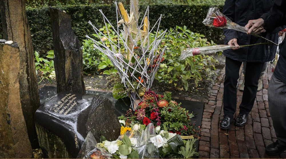 Mensen met bloemen bij donormonument